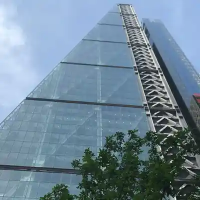 The glass exterior of the building with a tree in the foreground.