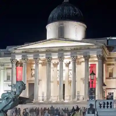 Exterior from Trafalgar Square illuminated at night.