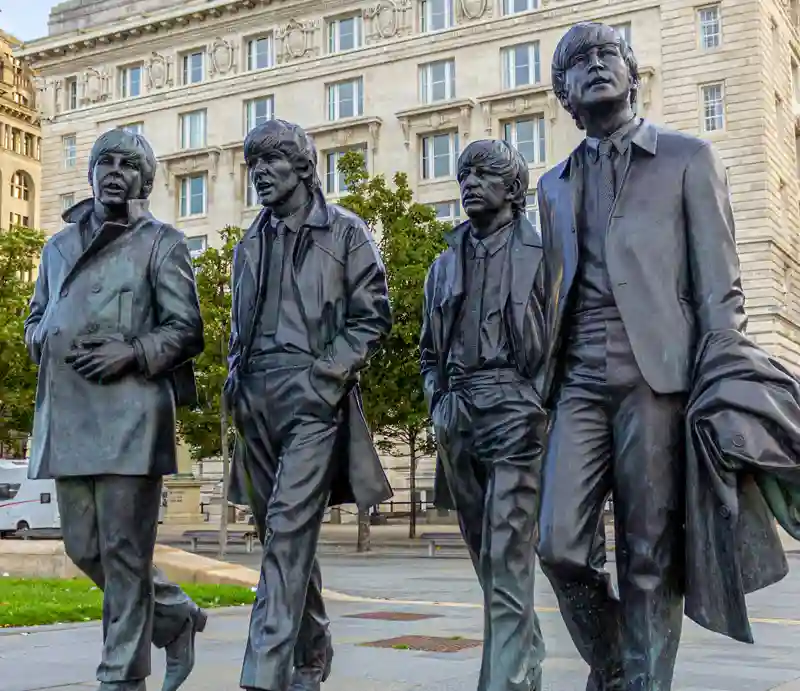 Beatles Statue Walking along the street at Pier Head in Liverpool.