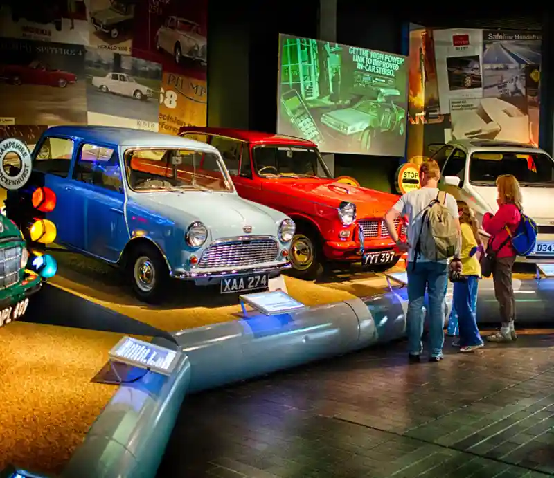 Classic cars Visitors looking at a light blue 1960s mini and other period cars.