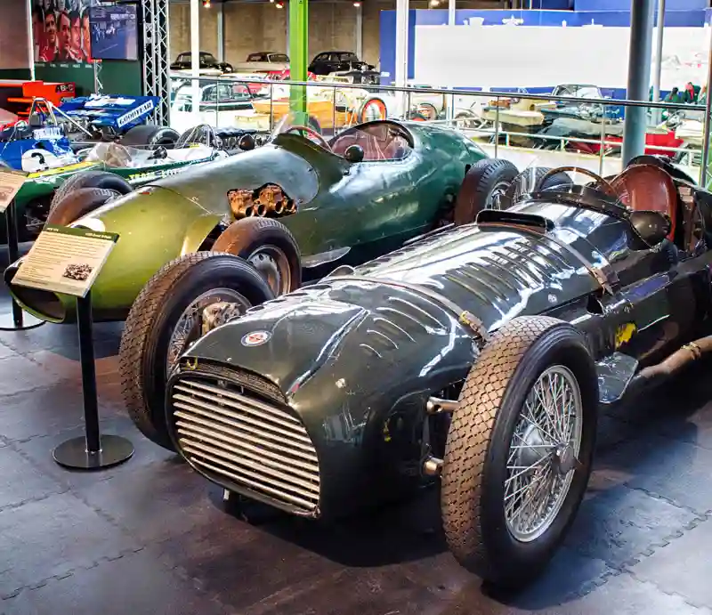 A green 1950s Formula One BRM and other fifties cars.