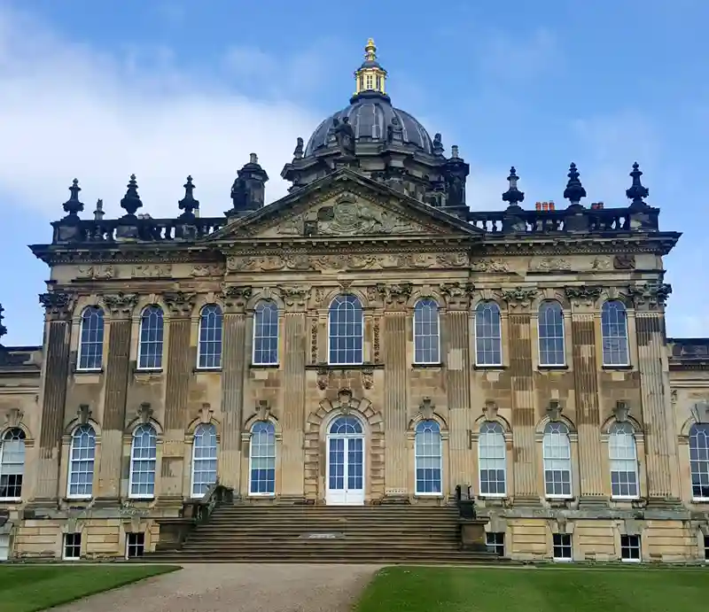 Castle Howard Palladian architecture of the facade with steps, two floors and ornate dome.