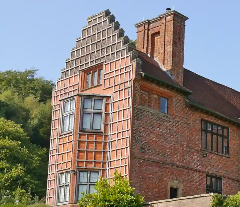 Tudor and Gothic Revival red brick exterior.