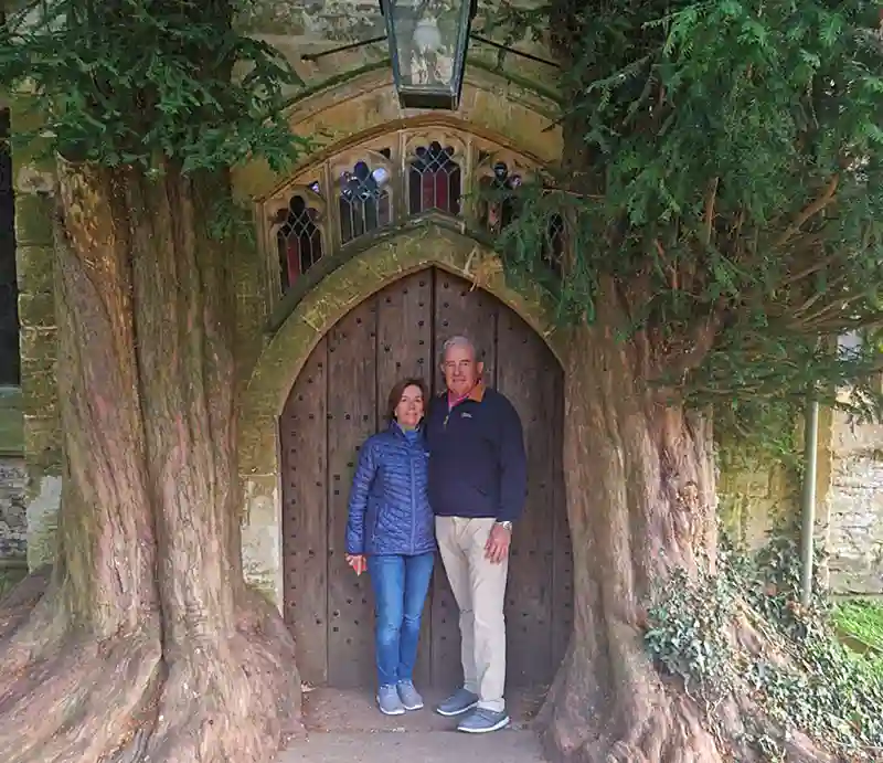 St Edward Flanked by yew trees, with tour guests.