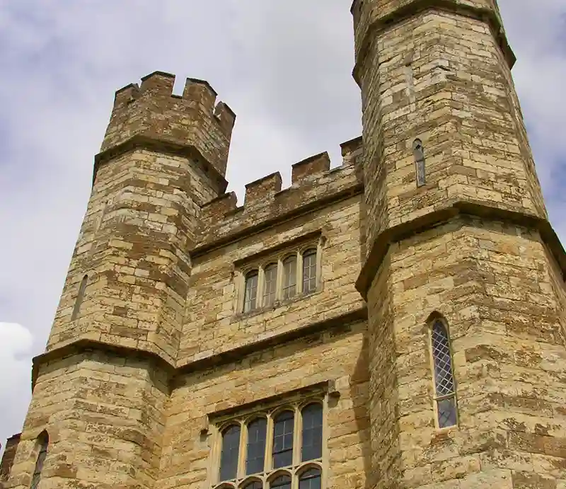 Stone exterior with two imposing crenulated turrets.