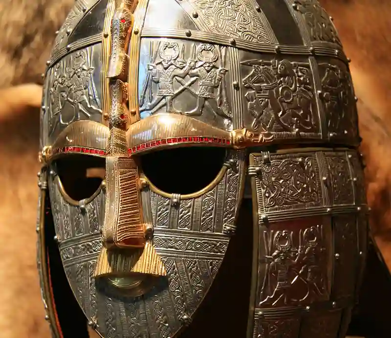 Saxon helmet Metal plaques with intricate gold and garnet decorations and faceplate forming a bird or dragon motif.