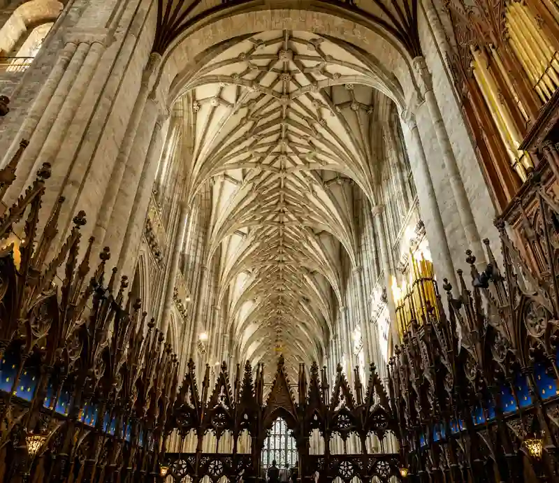 Medieval vaulted ceiling, stone columns and intricately carved woodwork.