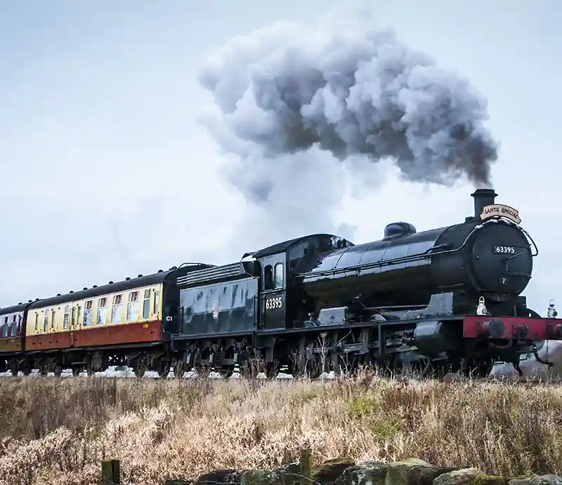 Embassy & Bolton Abbey Steam Railway Steam train with carriages crossing the moors.