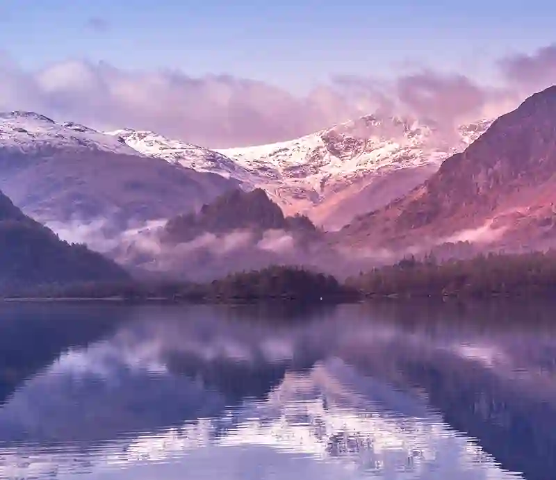 Snow-capped mountains reflected in the still waters.