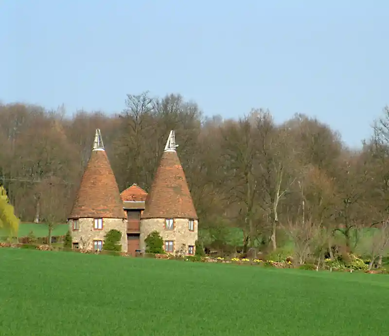Conical red tiled roofs of converted kilns.