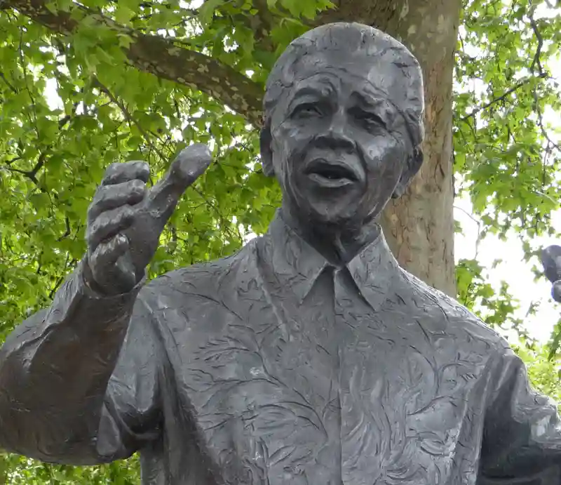 Nelson Mandella statue Wearing a florally marked jacket with outstretched arms.