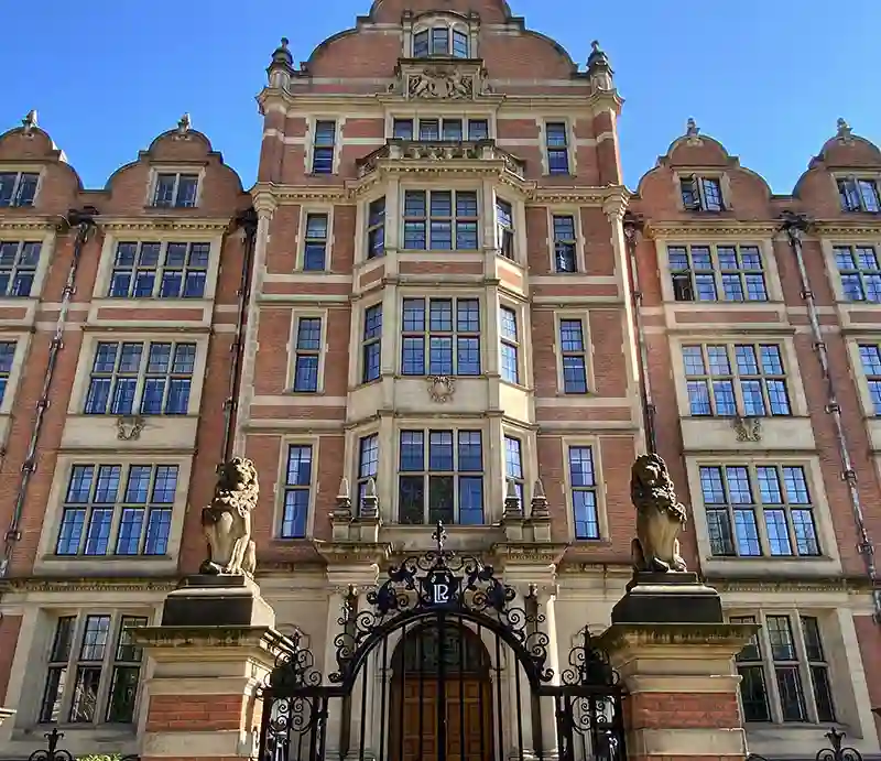 Lincoln Red brick and dressed stone building with ornate lion capped iron gates.