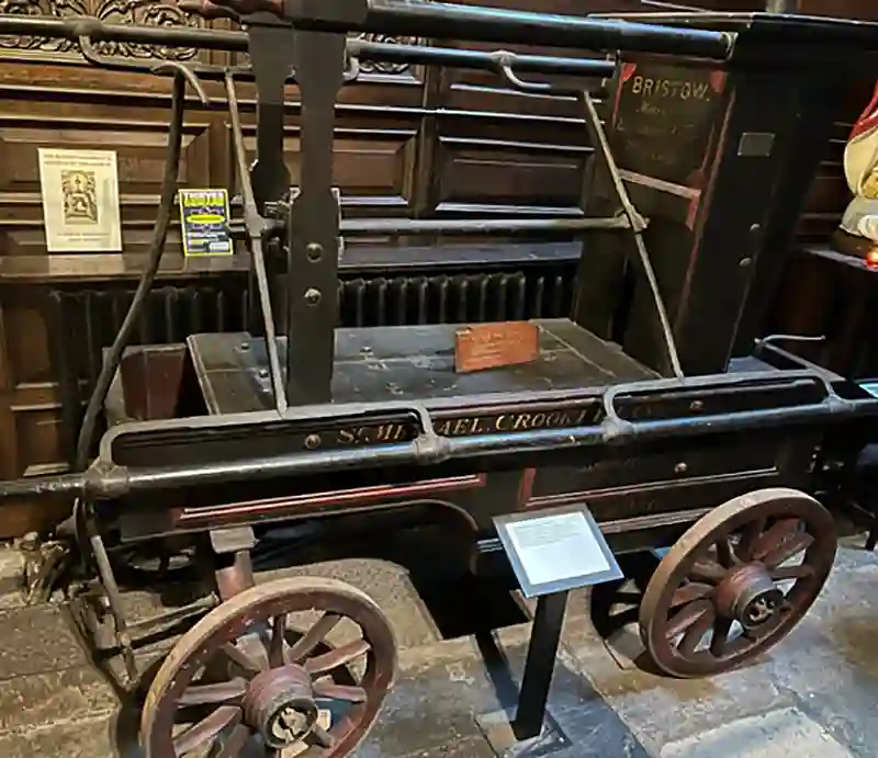 17th-century fire engine Iron pumping mechanism on antique wooden cart with wheels.