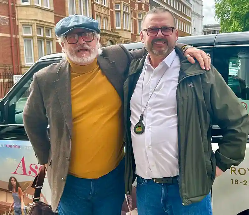Lee Cooper and Shane Healy Guide and cabbie standing by the black taxi.