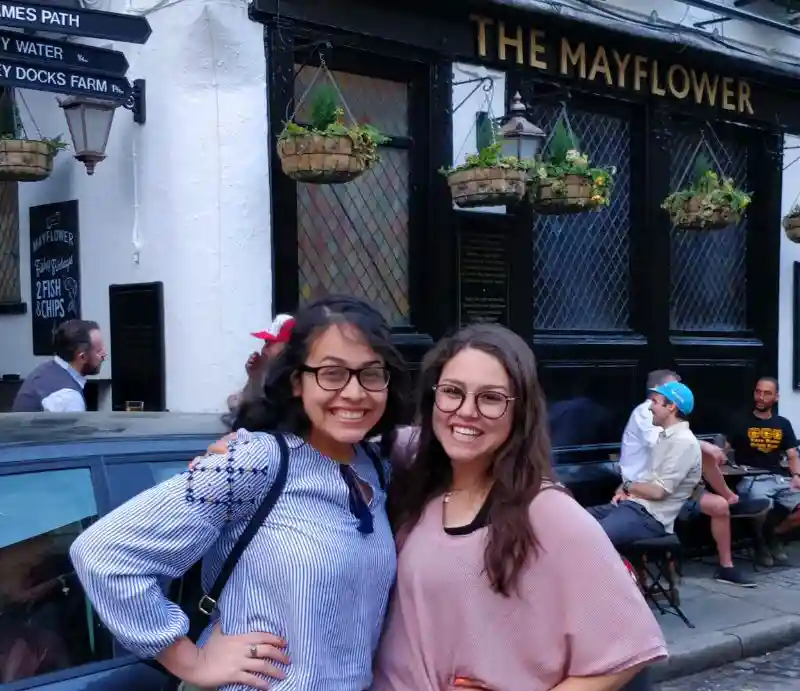 Mayflower pub Guests outside the dark wooden exterior with traditional signage.