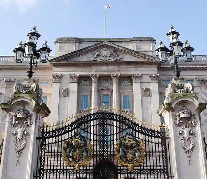 Buckingham Palace The facade through the ornate black & gold front gates.