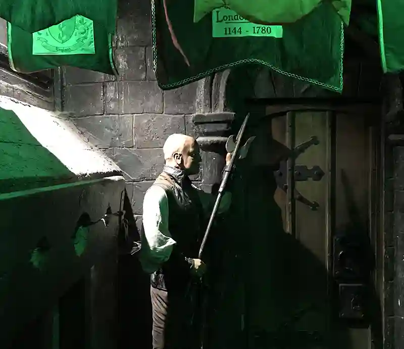 Clink Prison Guard with axe outside stone cell with eerie green light.
