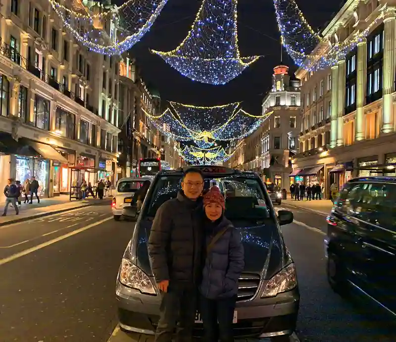 Guests in Regent Street With Christmas lights and illuminated shops.