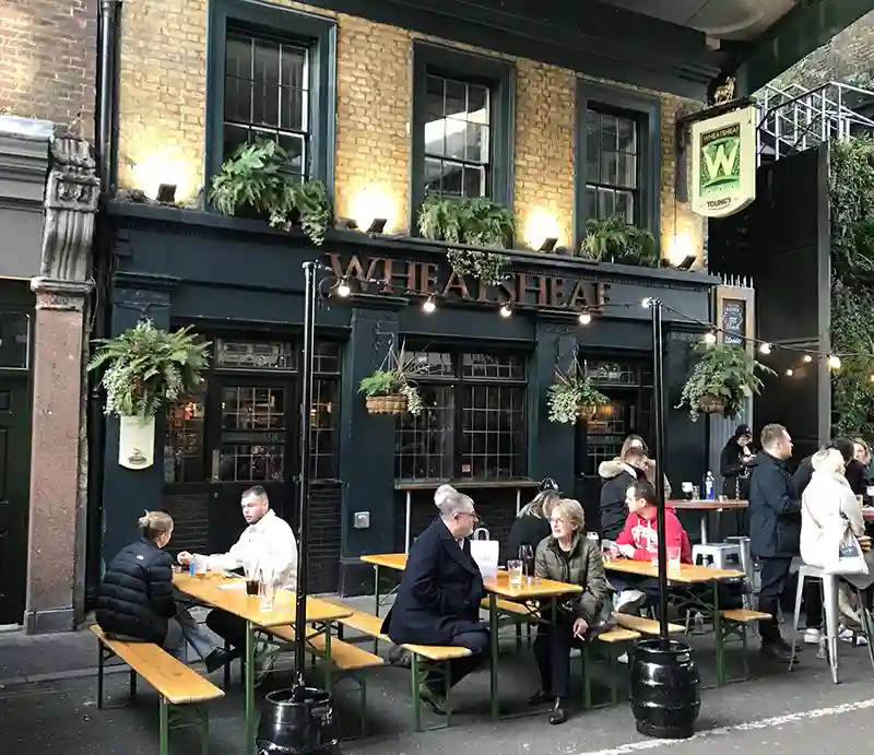 The Wheatsheaf Pub The early Victorian exterior with customers enjoying a drink.