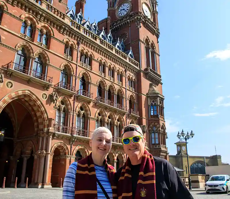Wearing Harry Potter scarves in front of the Gothic red brick building.