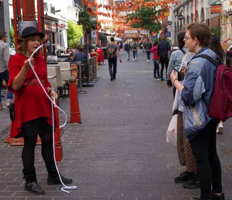 Jennifer performing magic The rope trick in London's Chinatown.