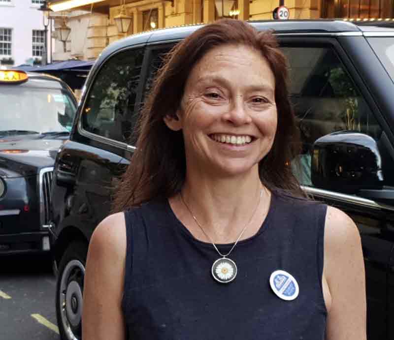 Karen Dawson tour guide Standing in front of a black taxi rank.