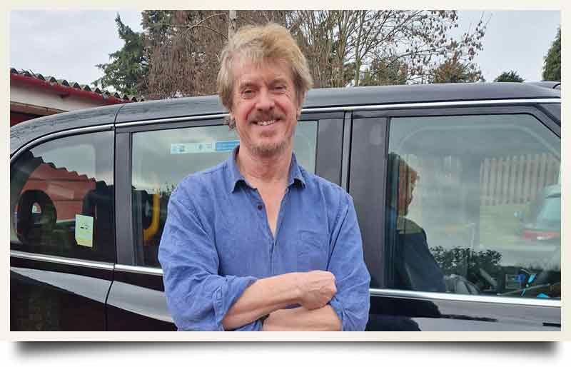 Chris Ratcliffe postcard Standing arms crossed by his London Black Cab.