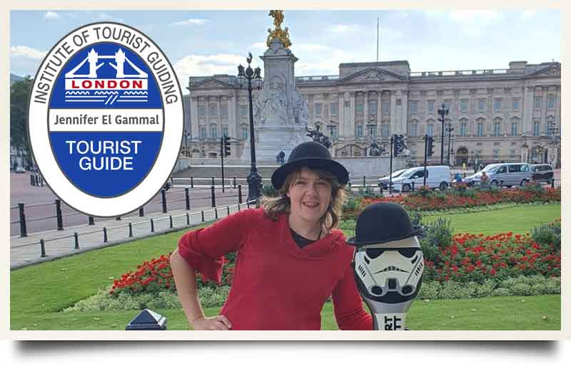 Jennifer El Gammal tour guide Infront of Buckingham Palace with her siganture red dress and hat.