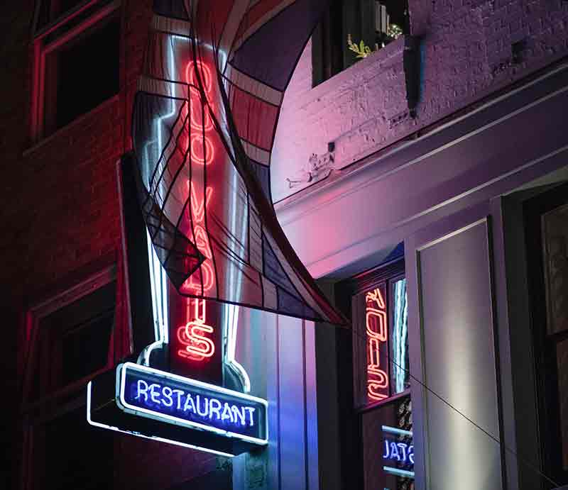 Quo Varis Restaurant Neon sign outside the building.