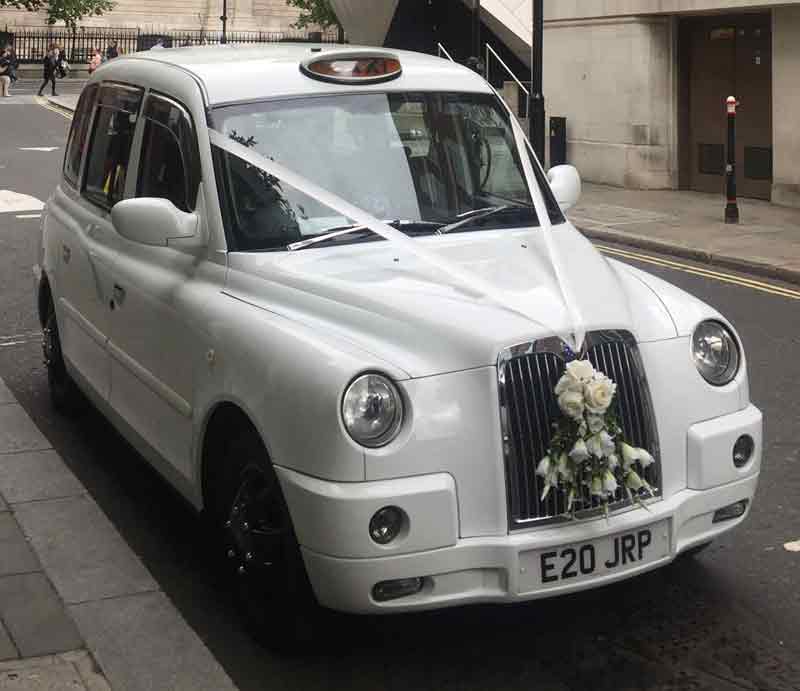 Decorated for a wedding with white ribbons and flowers.