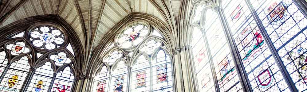 Arched stained glass with light shining through.