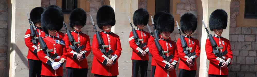 On parade in red uniform and bear skin busby hats.
